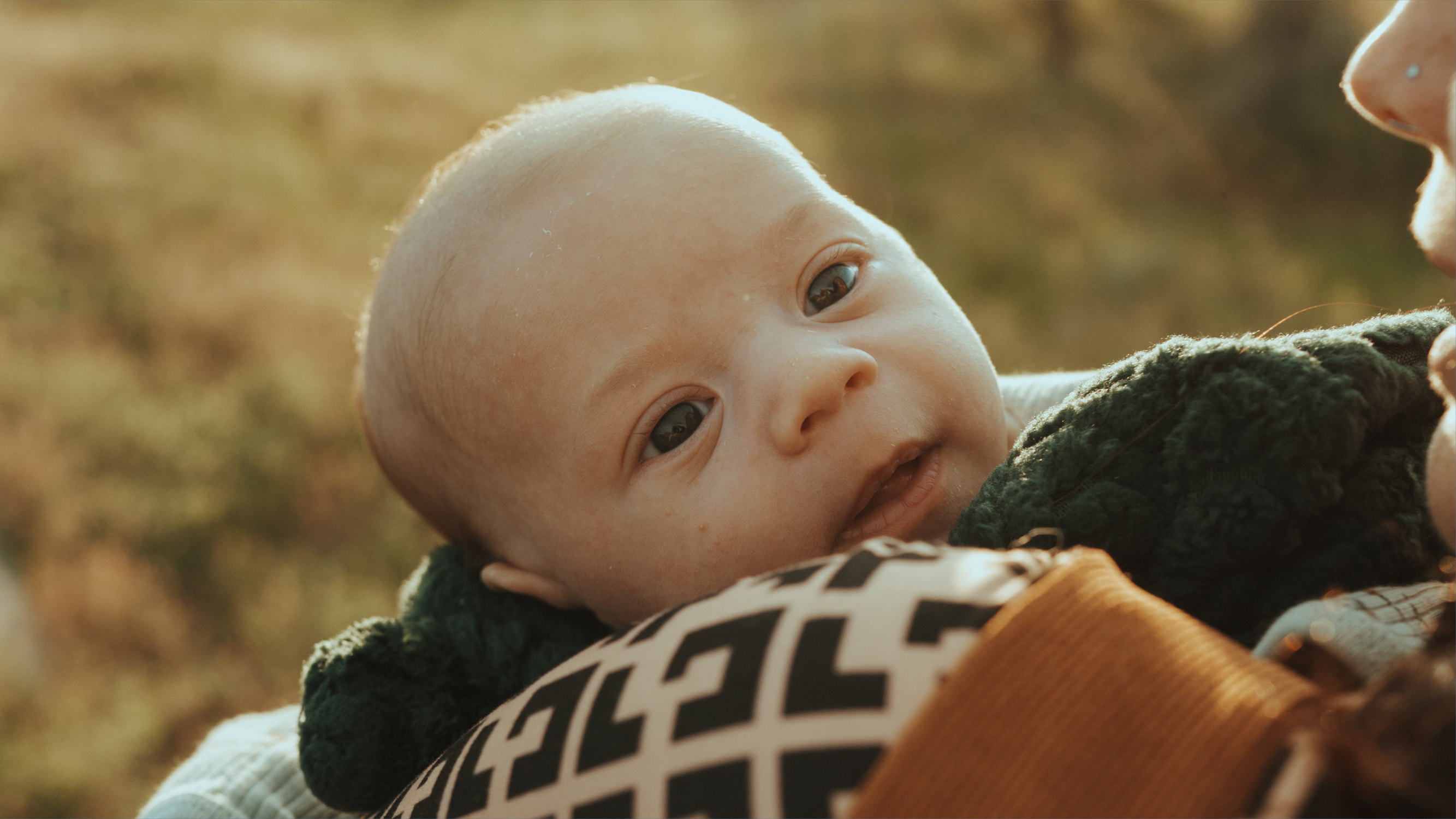 Close up of an infant being held.