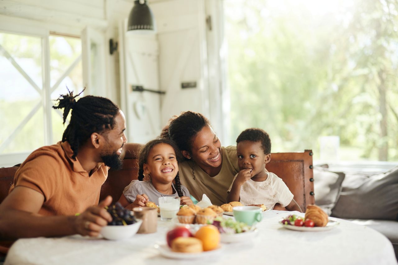 Family gathered around a table eating a meal together.