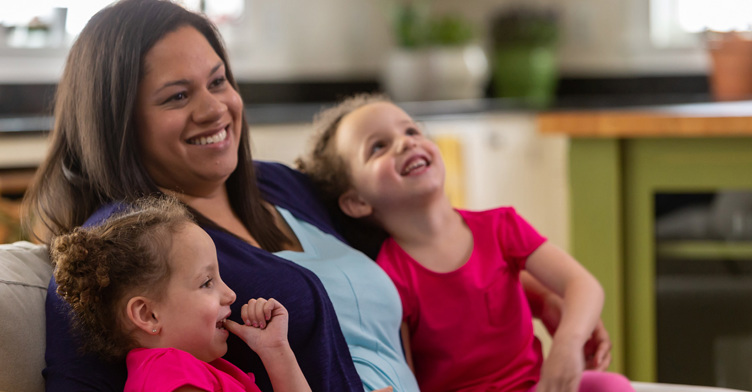 Nicole, treated for TTTS at Children's Colorado, sits with her school-age twin girls.