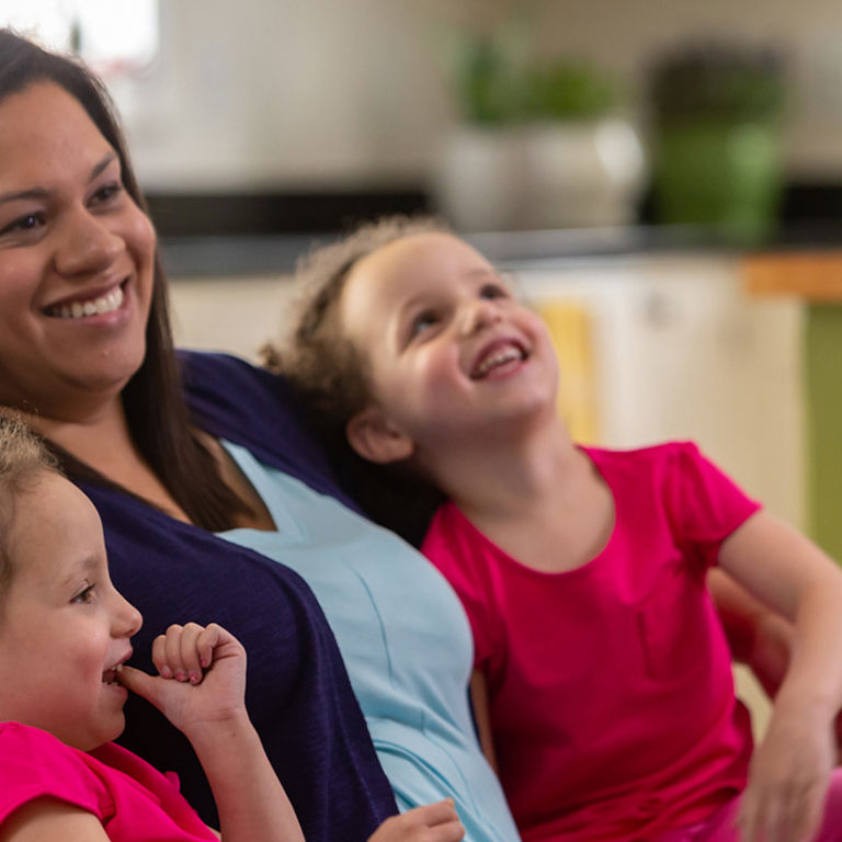 Nicole, treated for TTTS at Children's Colorado, sits with her school-age twin girls.