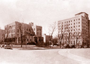 An old photo of the exterior of The Children's Hospital in 1932, showing two brick buildings with lots of windows.