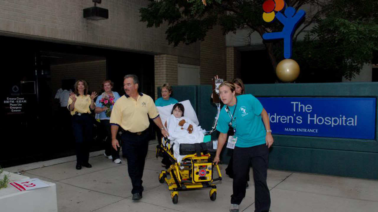 A child in a stretcher is wheeled out of the old Children's Hospital building