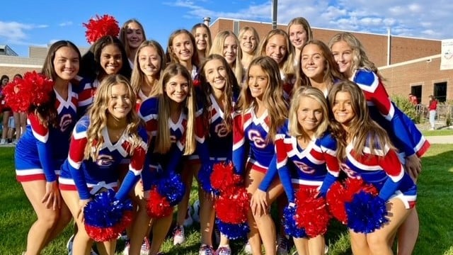 A cheerleading squad posing in uniforms