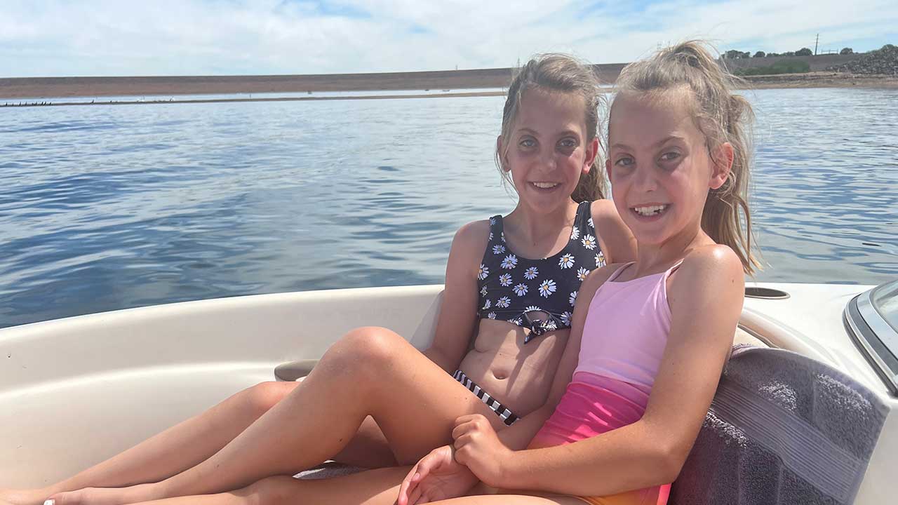 Kendall sits on a boat with her twin sister.