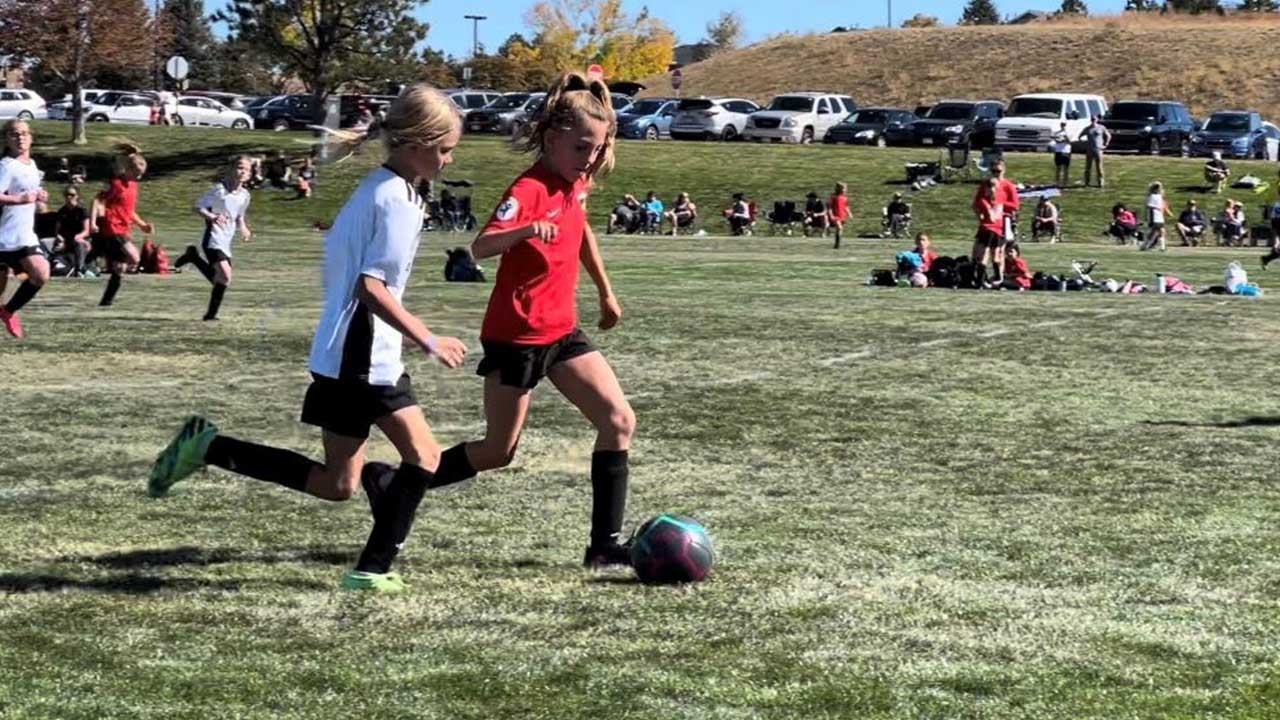 Kendall dribbles the ball during a soccer game. 