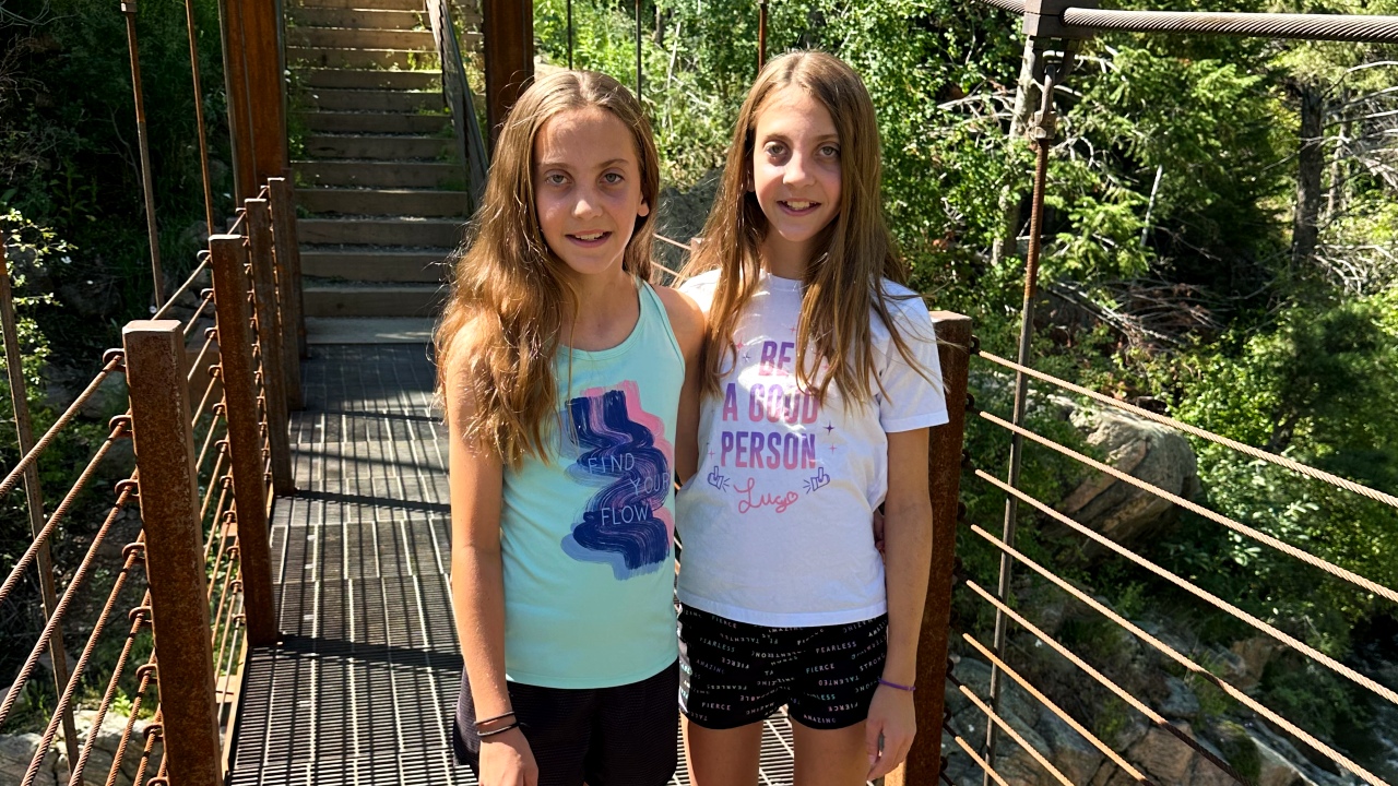 Kendall stands on a bridge with her twin sister.