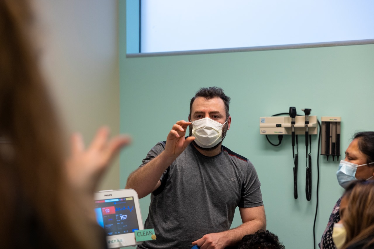 Juan uses sign language to communicate with Angel's care team.