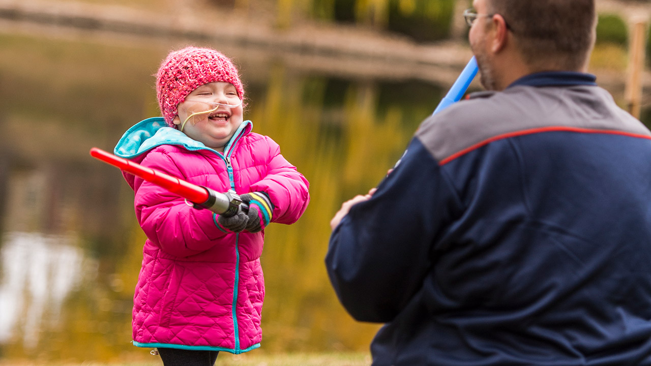 A 3-year-old girl who was diagnosed with thrombotic microangiopathy (TMA) plays with her parent.