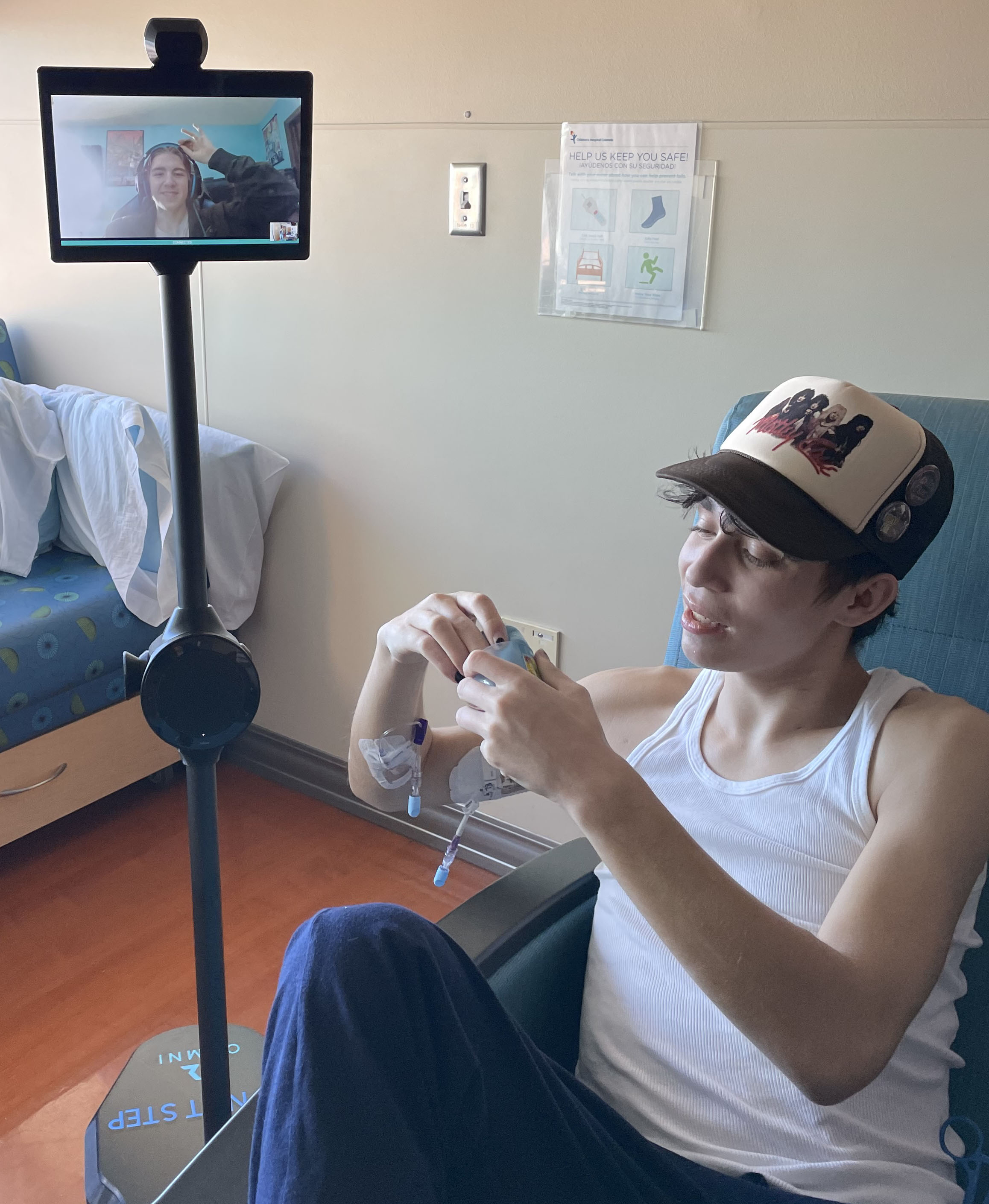 A friend visits Seth via a rolling tablet screen while Seth is in the hospital.