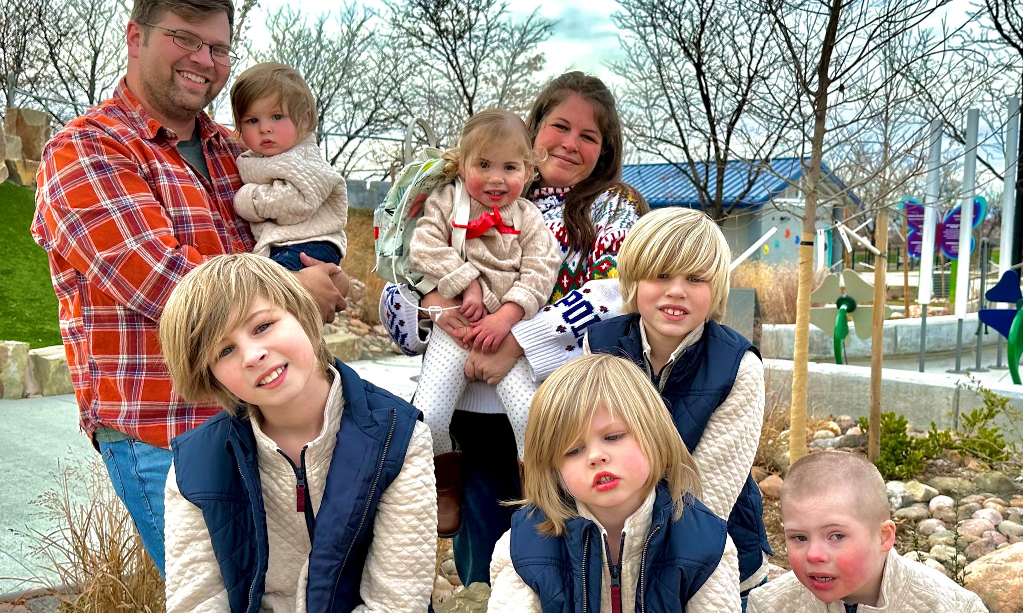 Willow posing with her family at a park 