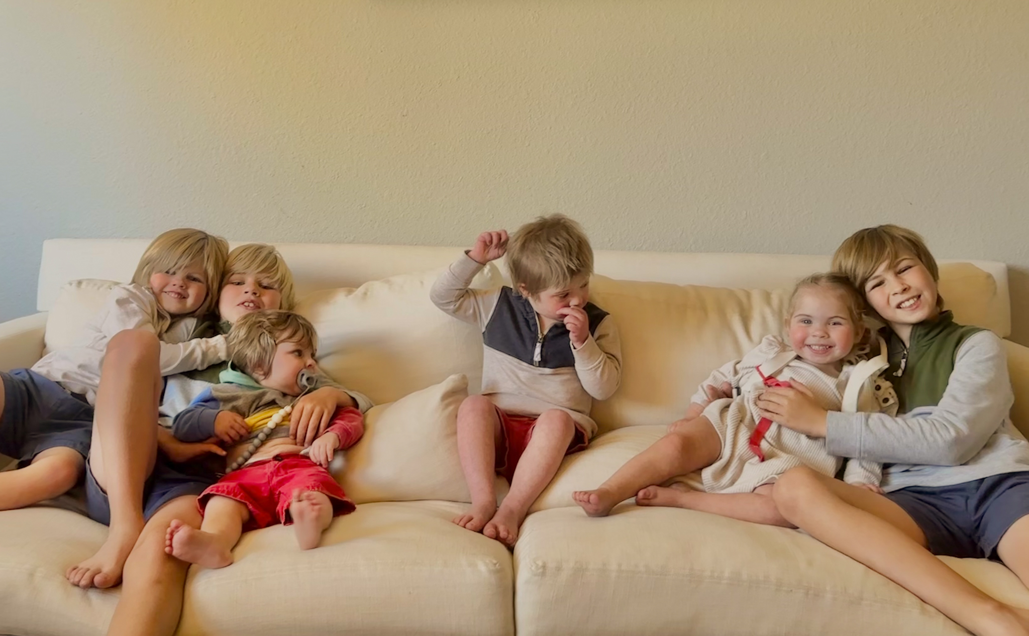 Willow and her five siblings posed and smiling on the couch