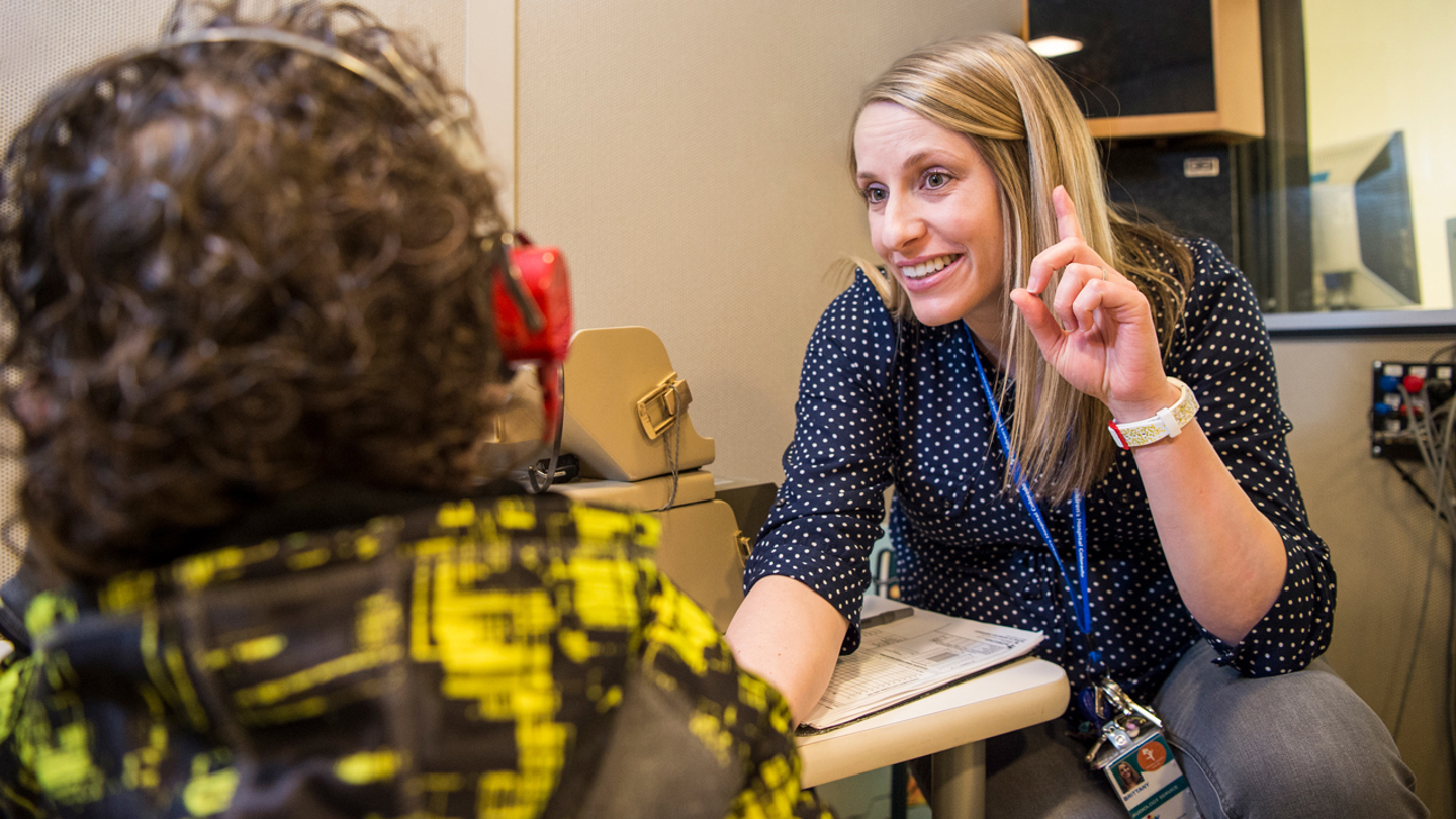 An audiology expert at Children's Hospital Colorado performs a hearing test on a young patient.