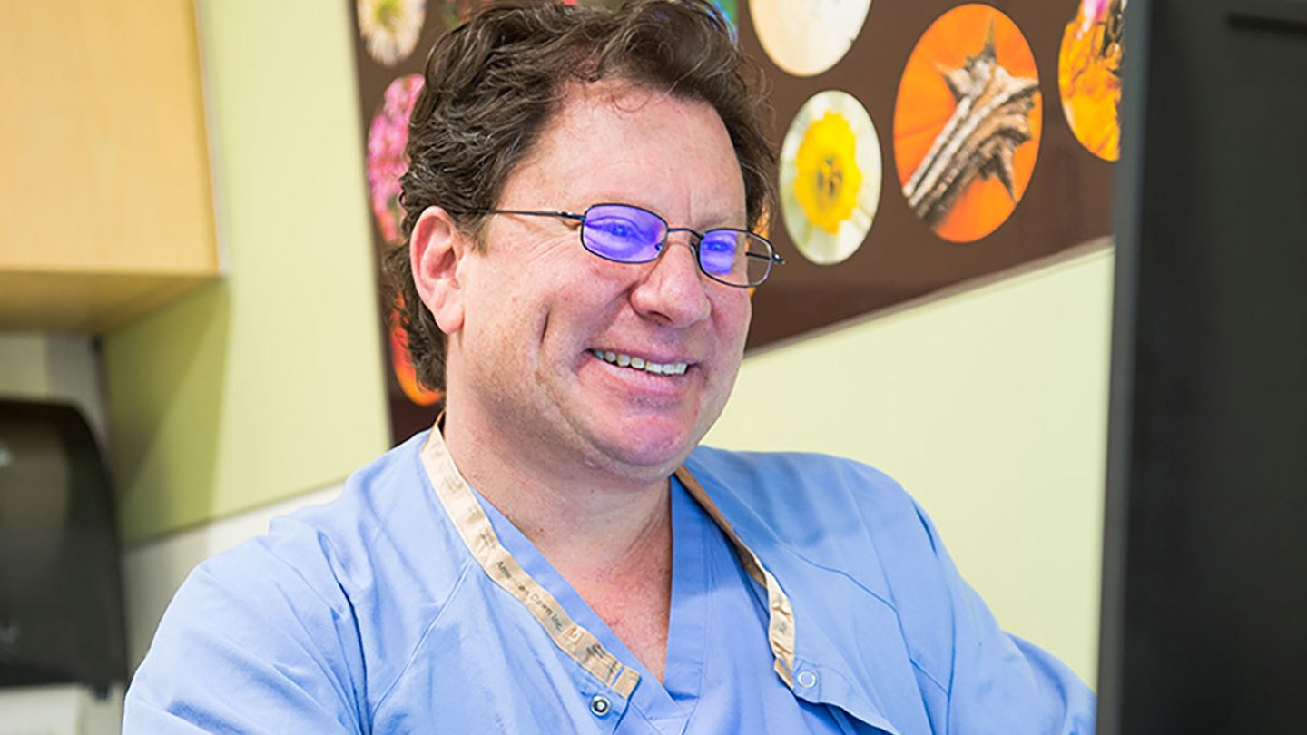 Dr. Belkind smiling and working on the computer