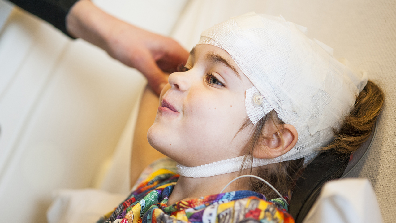 A girl with bandages wrapped around her head