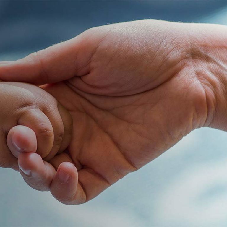 doctor holds childs hand