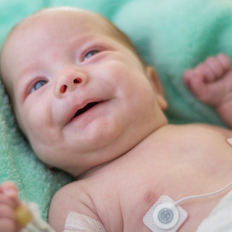 A close-up of a baby lying on a green blanket