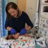 Doctor Theresa Grover, MD, listens to a baby's heart in the NICU at Children's Hospital Colorado.