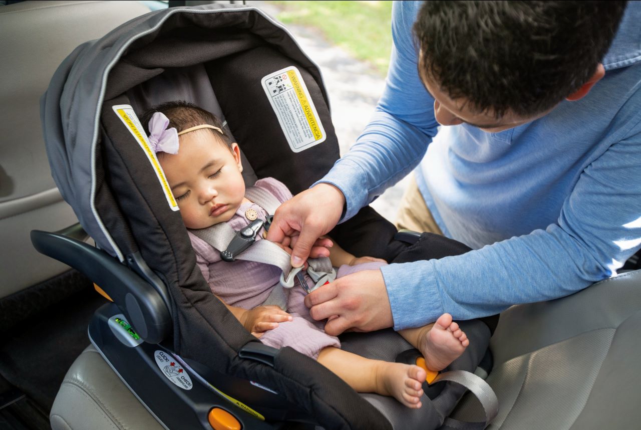 Father securing child in car