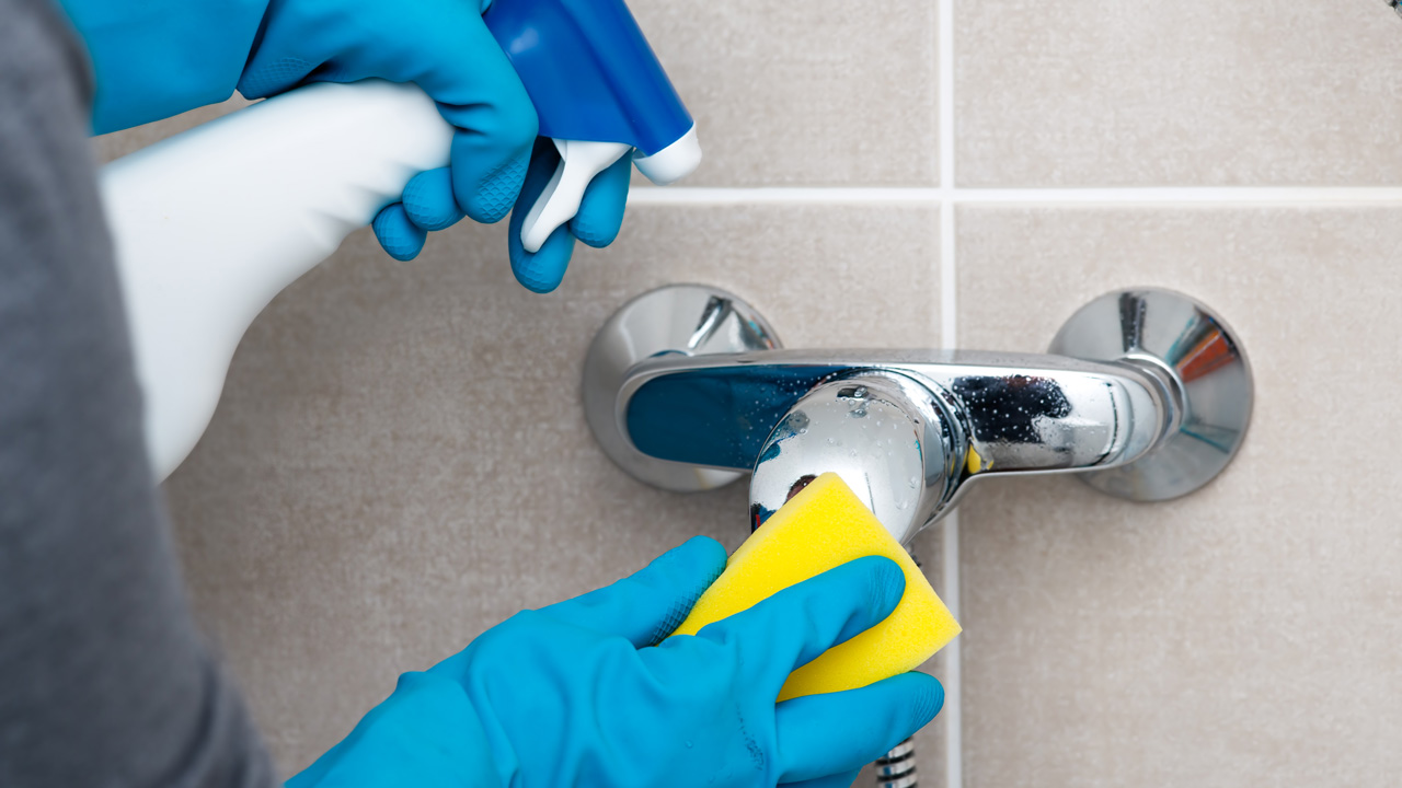 A parent cleans bathroom to prevent mold.