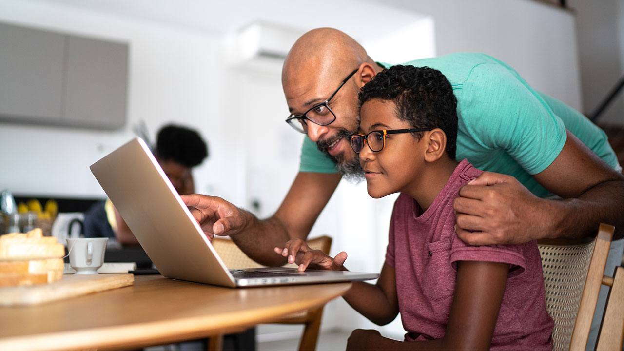 Father and son looking at something on a laptop.