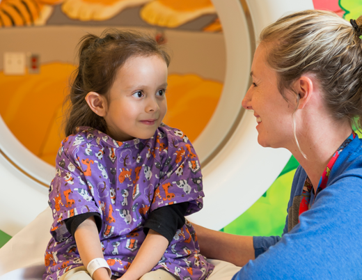 A pediatric radiologist comforts a young girl before a CT scan at Children's Colorado.