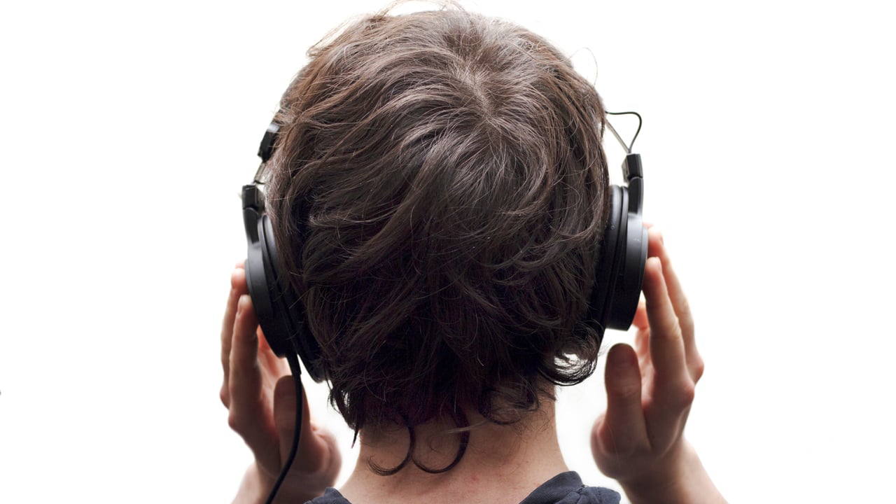 The back of a teen's head with headphones on