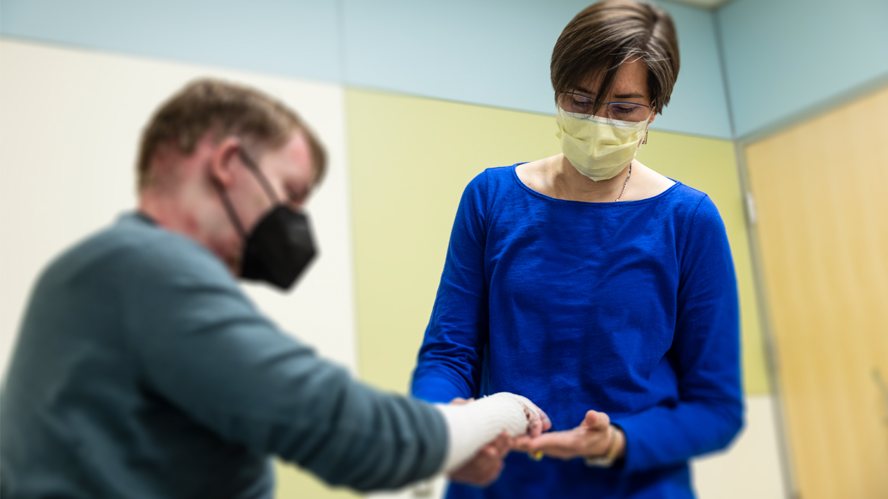 Dr. Anna Bruckner examines the hand of a patient with epidermolysis bullosa.