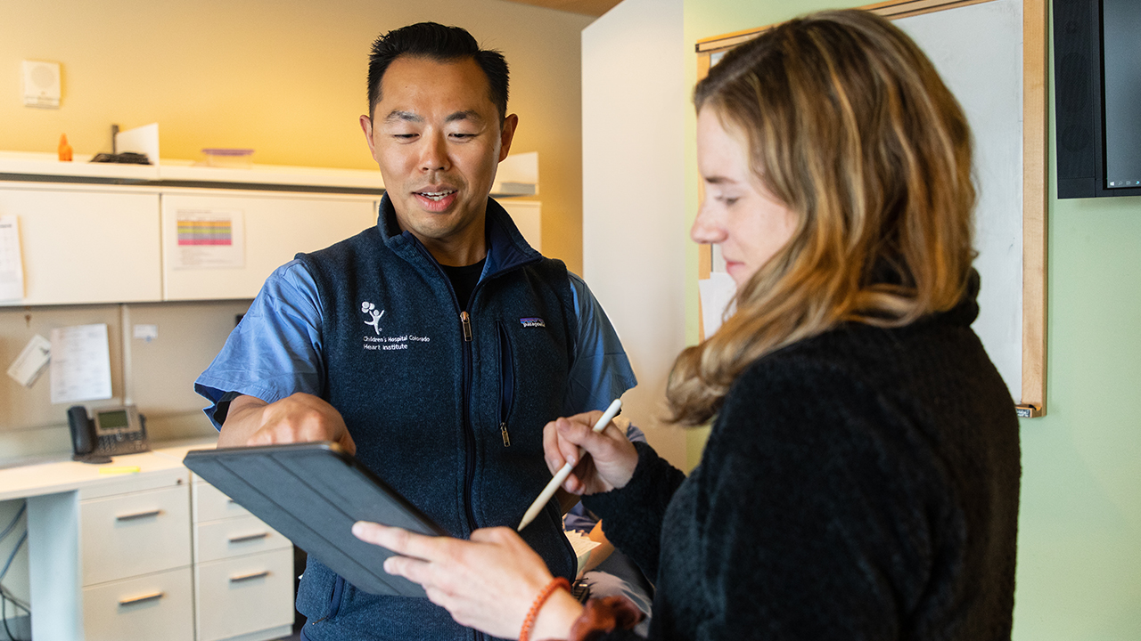 Two Heart Institute team members talk while looking at an iPad