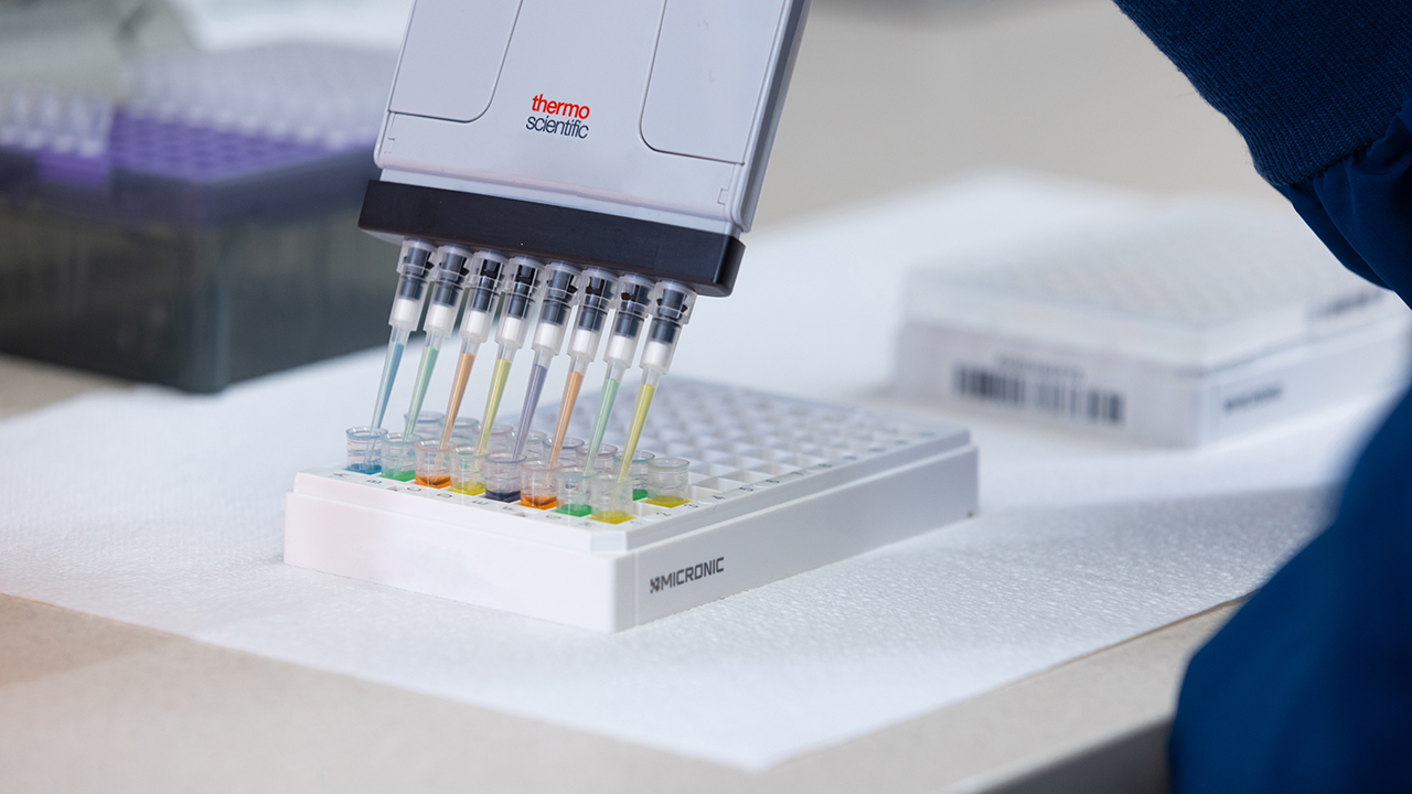 Tools for genetic testing in a scientific lab with colorful test tubes.