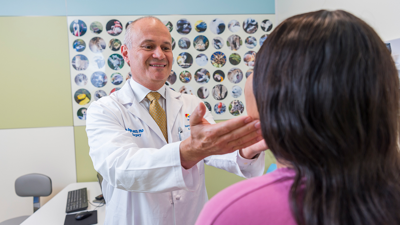 Photo of bariatric surgeon, Dr. Thomas Inge, examining a patient in the exam room. 