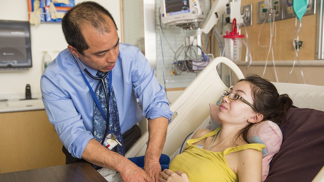 Dr. Liu examines a teenage girl's abdomen.