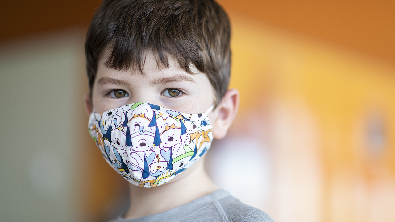 Young boy wearing a mask.