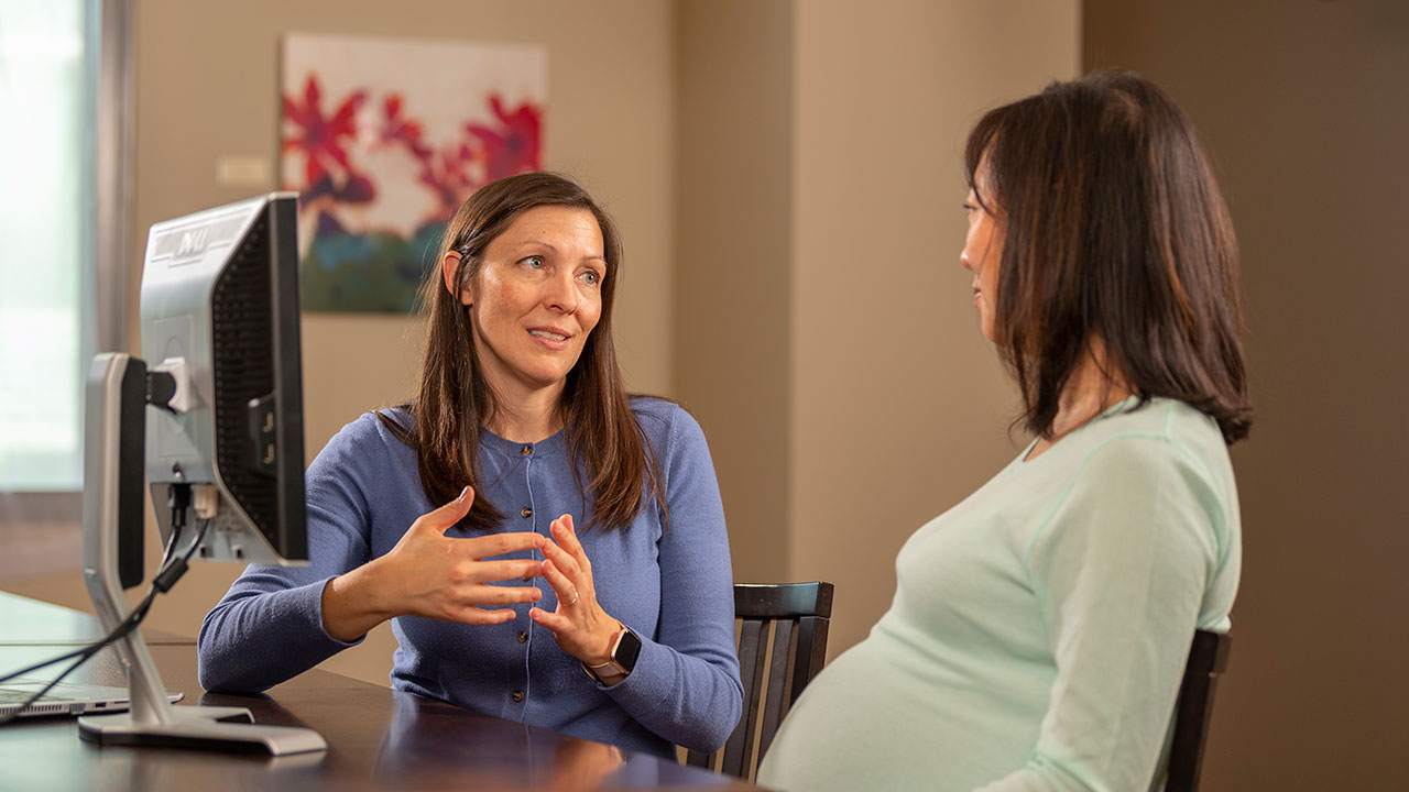 Dr. Dempsey talking with a pregnant mother.