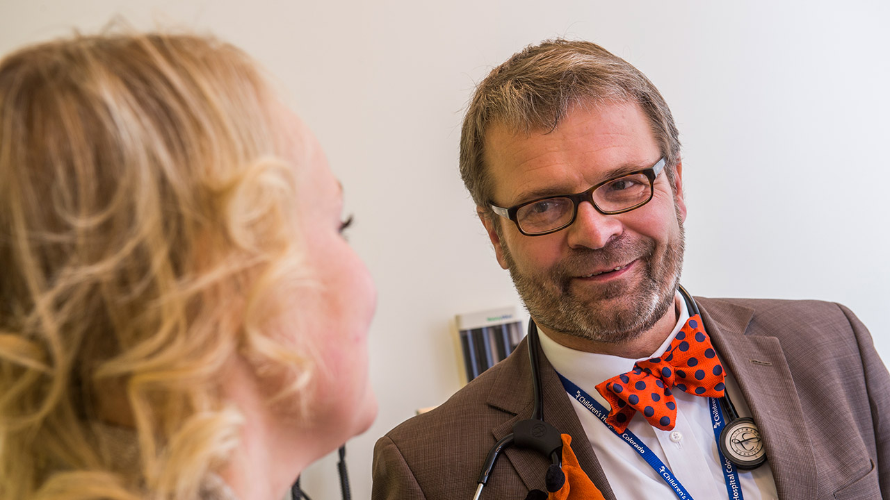 Dr. Jens Goebel discusses kidney transplant outcomes research while sitting in an exam room.