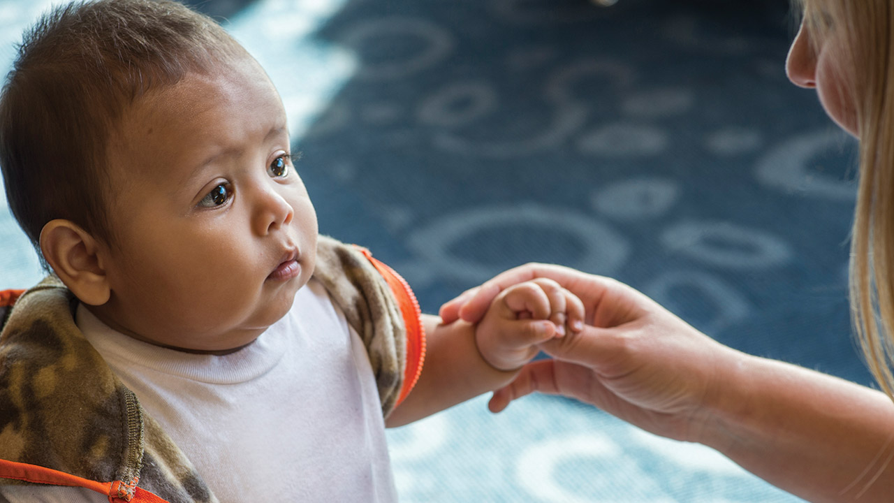 Dr. Sarah Sibbel examines a toddler's hand.