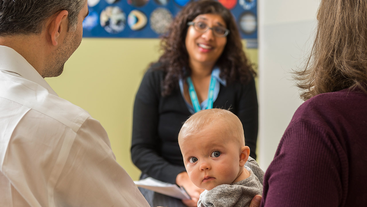 Dr. Vijaya Vemulakonda meets with a mom and baby.