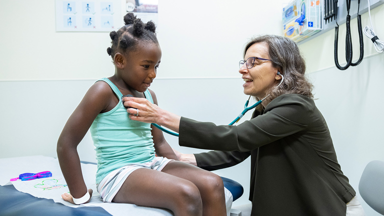 Child getting check with a stethoscope by another person 