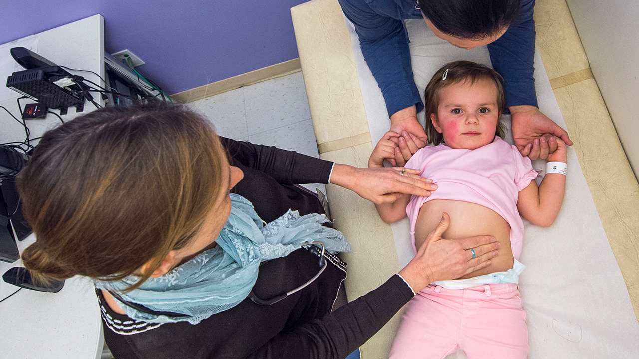 Doctor inspects young patient's stomach