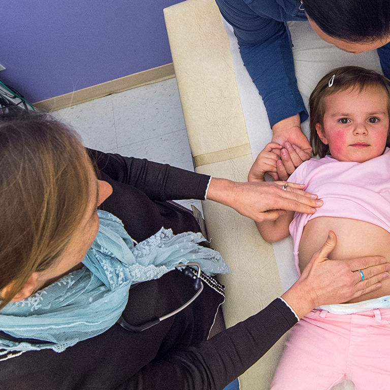 Doctor inspects young patient's stomach