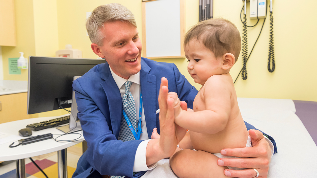 This is a photo of Dr. Cost with a baby in the exam room.