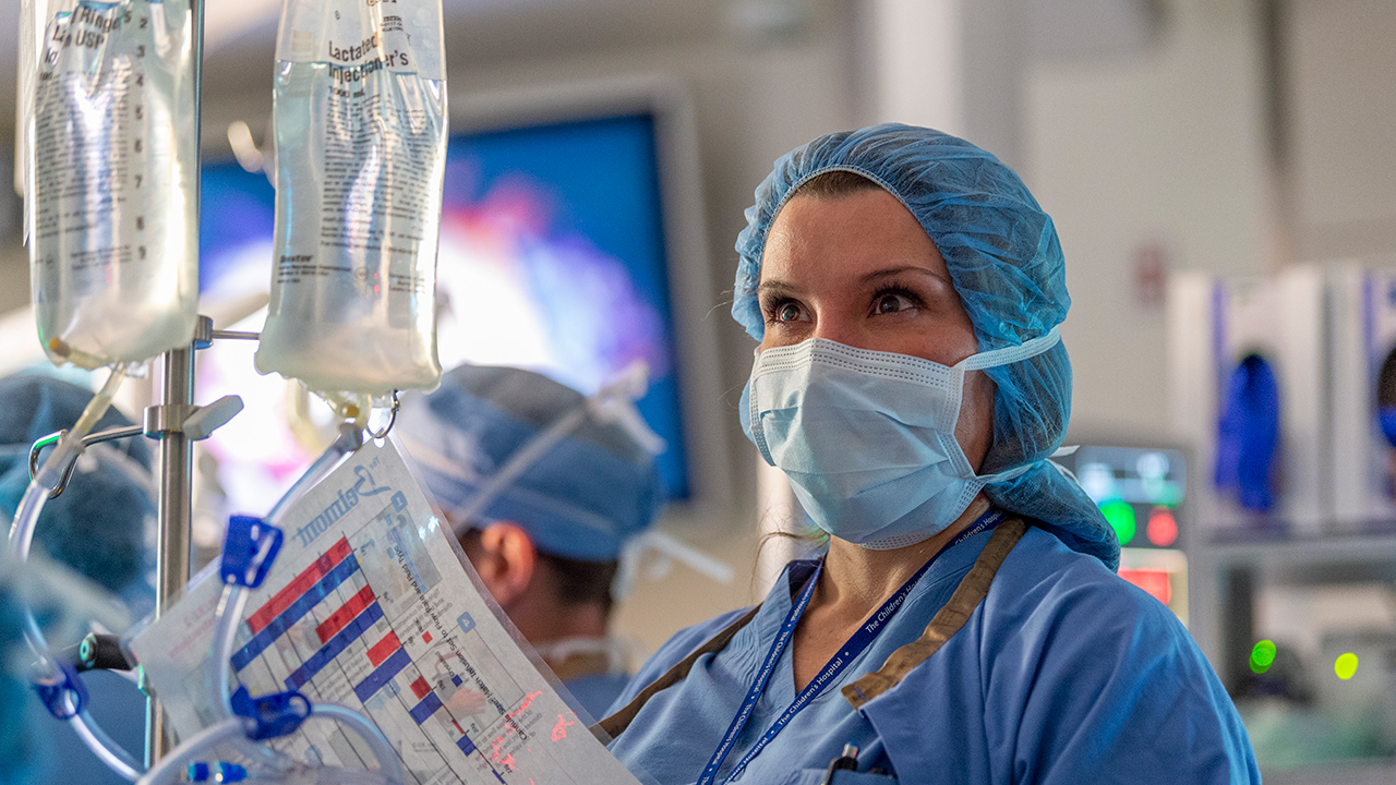 Nurse smiling and reading an IV bag