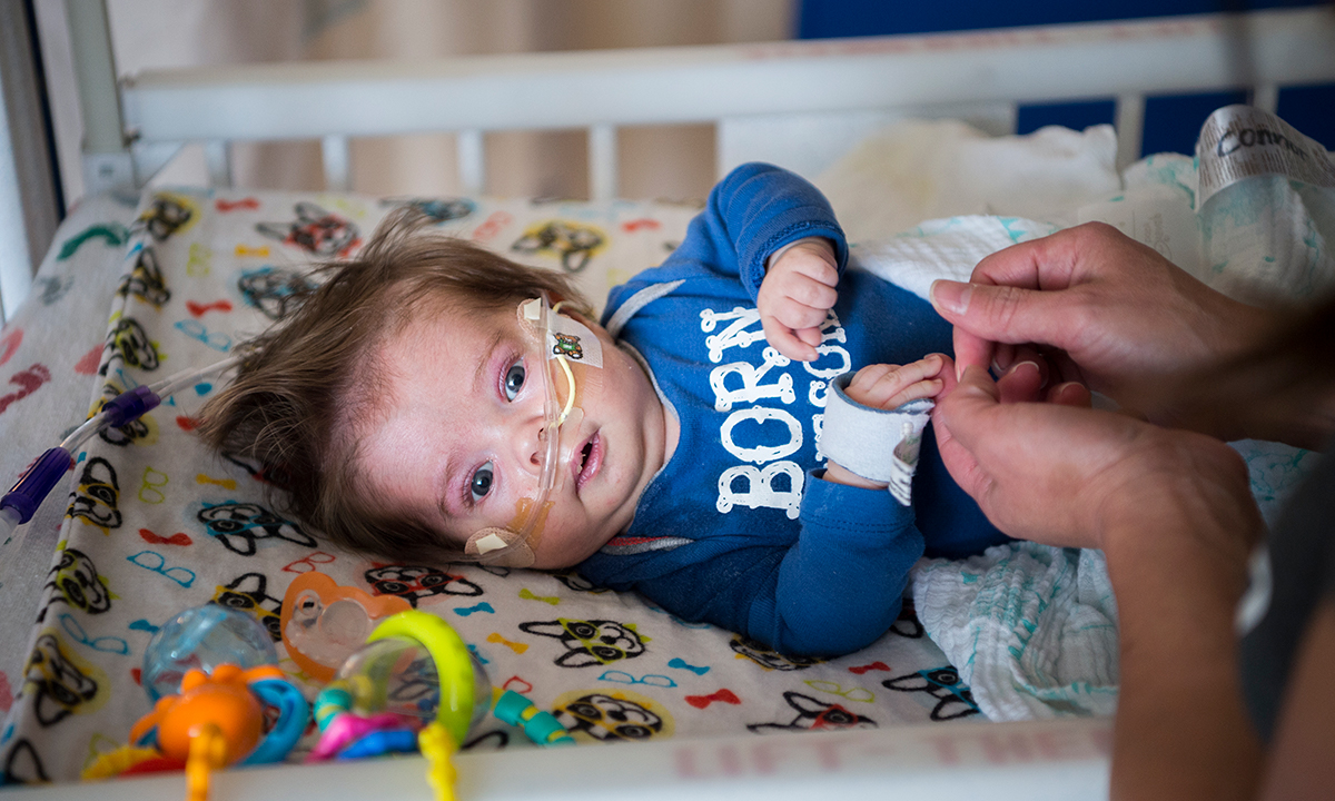 Baby in NICU with toys in the crib