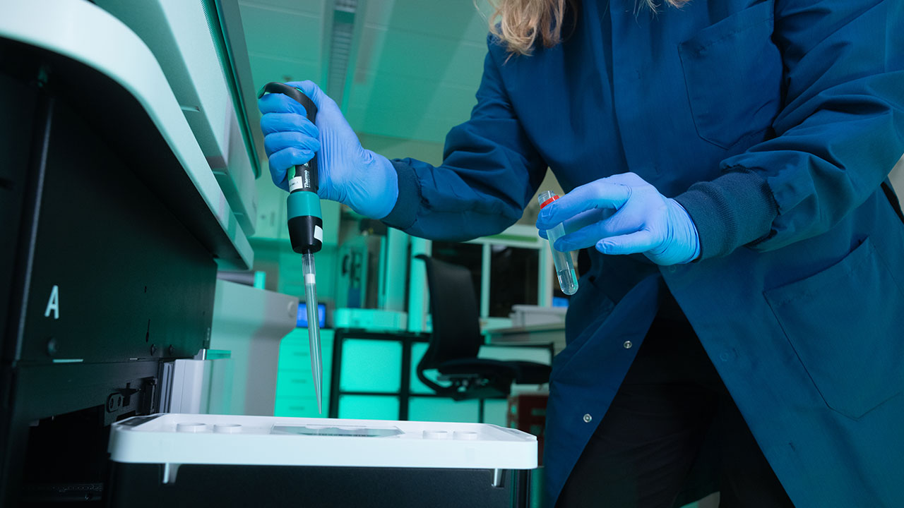 Female researcher conducting pediatric brain tumor research in a lab.