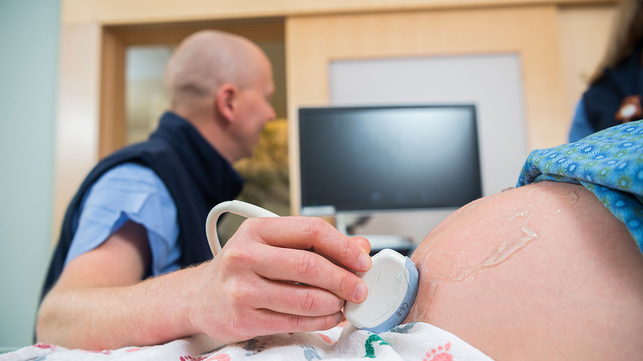 Doctor doing an ultrasound on a patient.