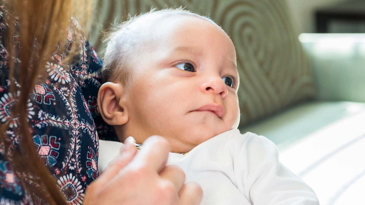 Young baby in mother's arms.