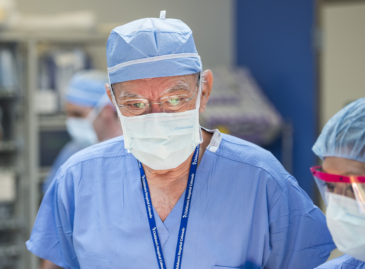 Dr. Peña close-up in scrubs with a surgical mask on preparing for surgery.