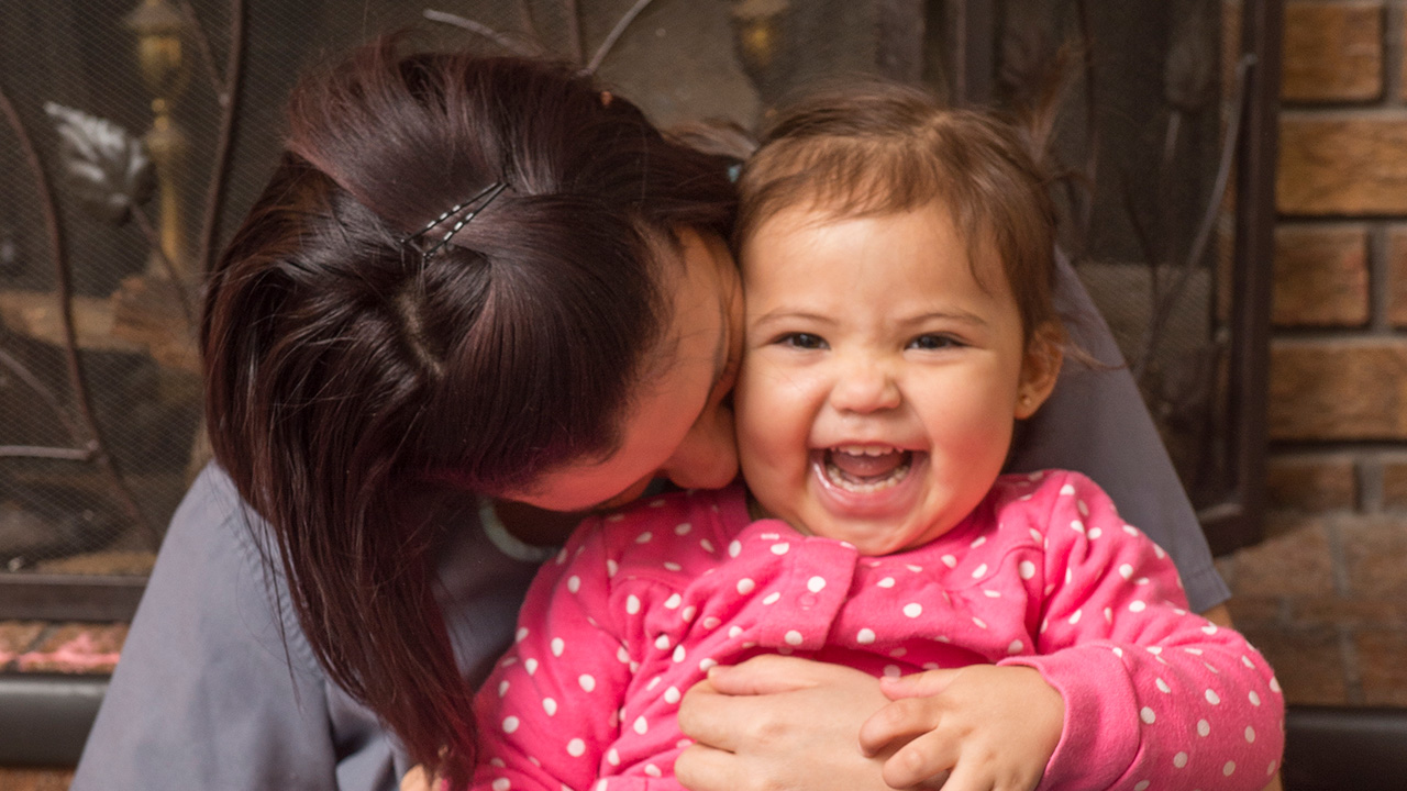 Mother snuggling with smiling baby